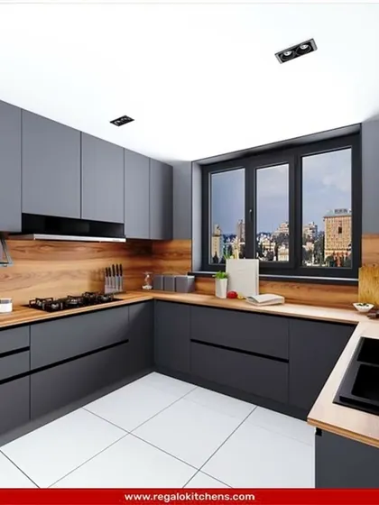 This L-shaped kitchen combines matte grey cabinets with a warm wood-look countertop and backsplash. The design is practical and stylish, with an integrated hob and sink that make the most of the available space.