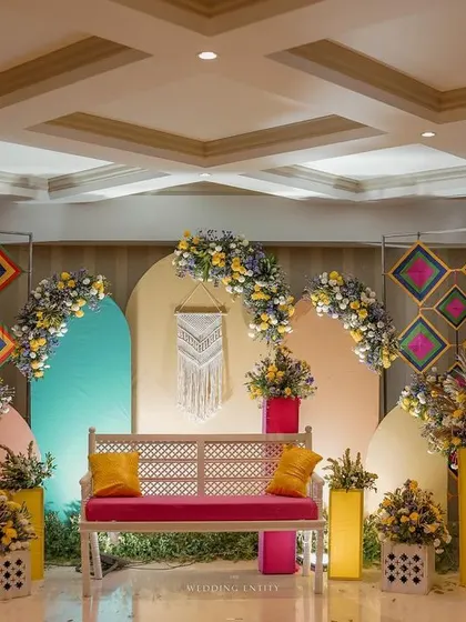 A wide view of our modern and colorful Mehendi seating arrangement, designed to be both comfortable for the bride and visually stunning for photos.
