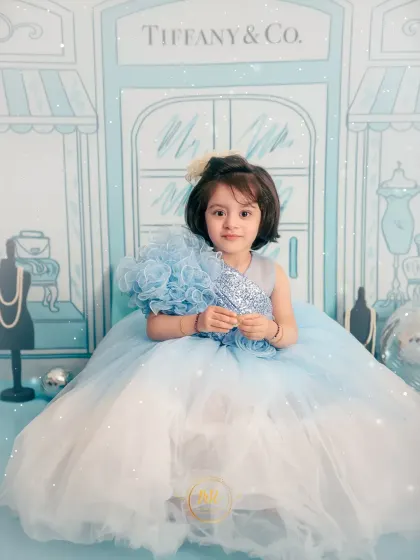 A serene portrait of a little girl in her blue gown, posing for her "Tiffany & Co." themed shoot.
