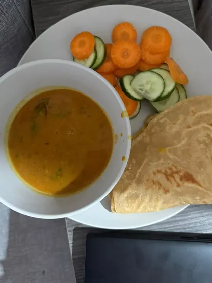 A comforting meal of dal, paratha, and a side of sliced carrots and cucumber. This is a balanced meal for our client focusing on inch loss.