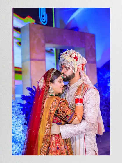 A tender moment as the groom kisses the bride's forehead. This intimate gesture, captured in a beautiful frame, is a testament to their love.