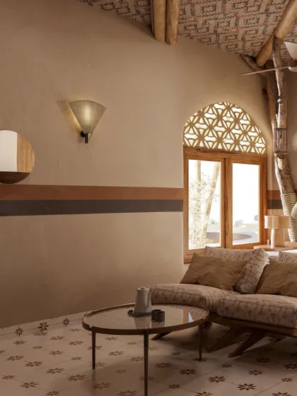 The wall in this room features bands of earthy color, adding a subtle decorative element. The latticed window, known as a *jali*, casts intricate patterns of light and is another nod to traditional Indian architecture.