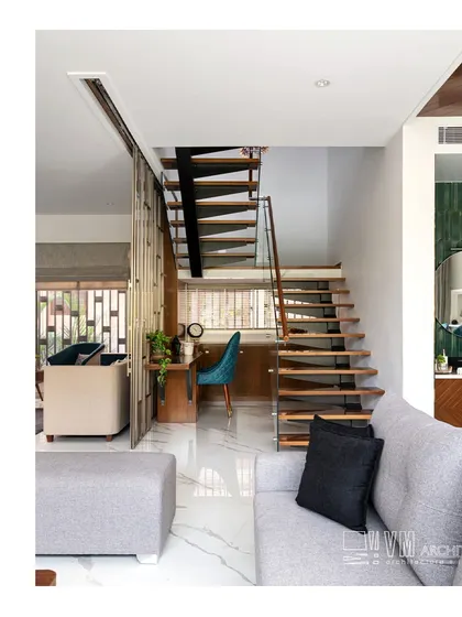 The workspace integrated under the staircase at Sa Sha Villa, featuring a sleek wooden desk and a stylish teal chair, demonstrating my approach to maximizing functionality.