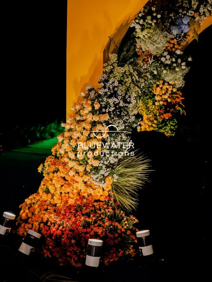 An impressive floral installation for the Haldi, with a cascade of orange and yellow marigolds creating a bold statement.