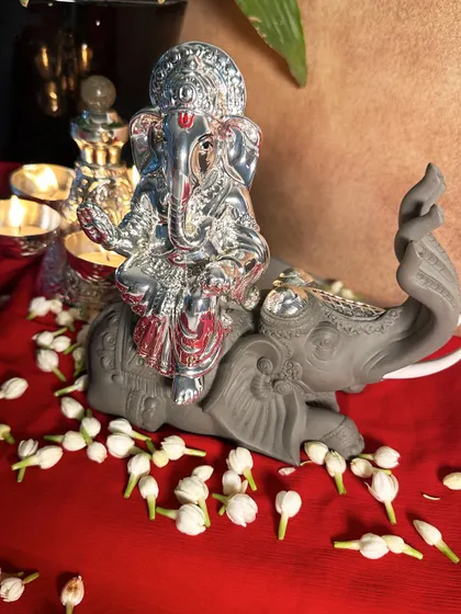 This silver-plated Ganesha idol, seated on a beautifully detailed elephant, is a symbol of auspiciousness. I designed it to be a centerpiece for your home temple, surrounded by fresh jasmine flowers.