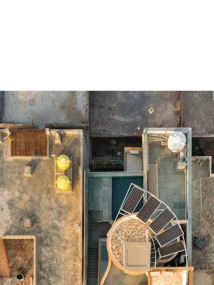A detailed aerial view of the roof shows the solar panels, water tanks, and the unique spiraling form. This image clearly illustrates the integration of sustainable technologies into the architectural design.