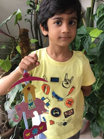 This student displays the intricate elephant-themed hanging he made. This craft project required cutting, pasting, and assembling, all of which are excellent for developing dexterity.