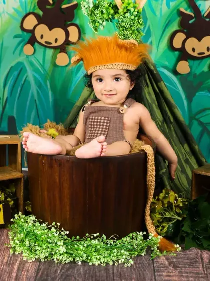 This little lion is king of his domain! A cute portrait of a baby in a lion costume, sitting in a bucket prop.