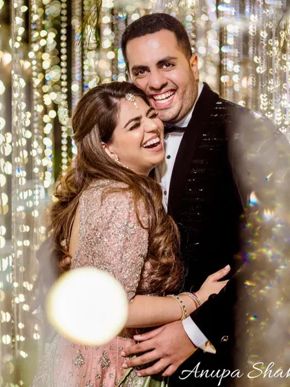 A moment of pure, uninhibited laughter. This candid shot, with a touch of light flare, captures the genuine joy and fun of the couple's engagement night.