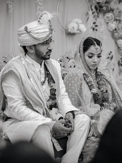 A solemn, candid moment from the wedding ceremony in black and white. This photo captures the traditional and serious aspects of the rituals.