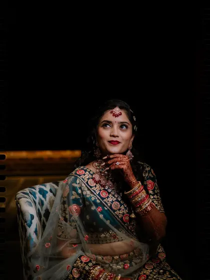A pensive solo portrait of the bride, with creative lighting and framing.