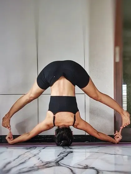 A wide-legged headstand variation that challenges balance and opens the inner thighs. Inversions like this bring fresh blood to the brain, improving clarity and focus.
