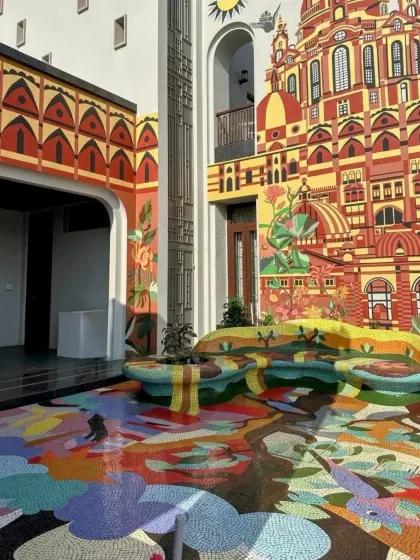 Another view of the Rajkot residence, this image shows how the floor mosaic and wall mural work together to create a single, cohesive artistic statement. The functional, custom-designed bench is also part of the mosaic, blending furniture and art.