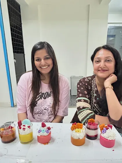 Two friends with their collection of six dessert candles from a weekend workshop.