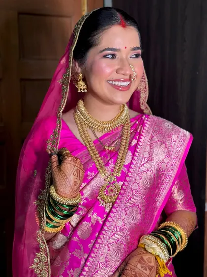 A radiant smile from my Maharashtrian bride. The gold jewelry and the vibrant pink of her Banarasi silk saree are beautifully complemented by a luminous and fresh makeup look.
