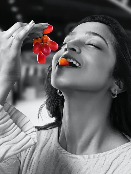 Another image from the GoFresh campaign, this time with grapes. The model's joyful expression and simple styling convey a message of healthy, happy eating.