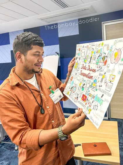 Holding up the finished sketchnote from a Google event. It's a great feeling to see all the ideas from a session come together in one cohesive artwork.