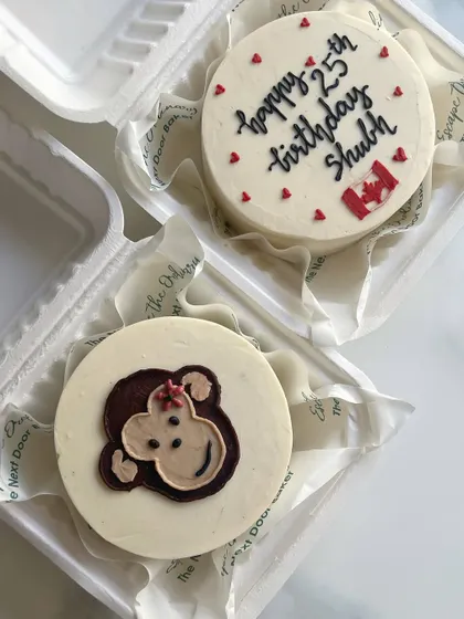 A couple of custom mini cakes for a birthday celebration. One features a cute monkey, and the other has a Canadian flag for someone celebrating away from home.