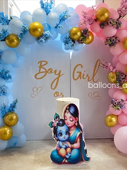 A closer look at the 'Boy or Girl' gender reveal backdrop, featuring adorable illustrations of baby Krishna and Radha.