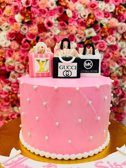 A full view of the pink quilted cake topped with luxury brand shopping bags. It's a stylish and popular choice for fashion lovers.