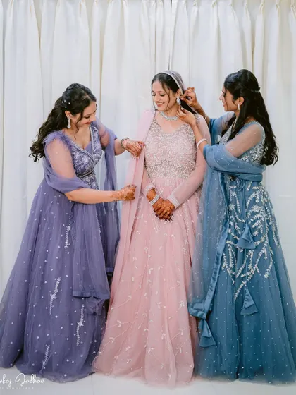 The bride's maids helping her get ready, a sweet moment of friendship.