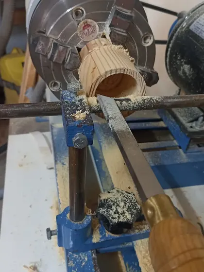 Hollowing out the inside of the box with a scraper. The 4-jaw independent chuck is holding the piece securely.