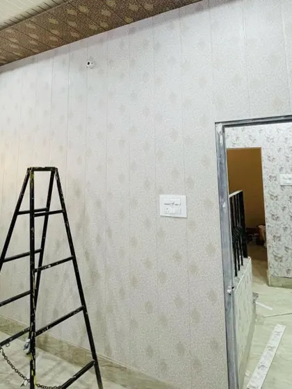 A simple yet elegant wallpaper with a subtle geometric pattern being installed. This is a great way to add texture to a room without overwhelming the space.