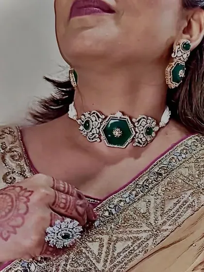 A side profile showing how the emerald choker looks when worn. It also gives a glimpse of the matching earrings and a statement AD ring.