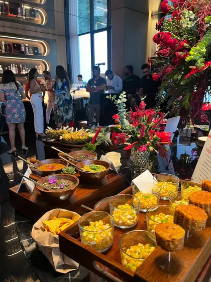 A wide shot of our Mexican food station, featuring a variety of salsas, corn salads, and other delicious toppings for tacos and nachos. The setup is bursting with color and flavor.