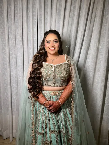 A beautiful full-length shot of the bride ready for her Sangeet. The long, flowing waves are perfect for a night of dancing.