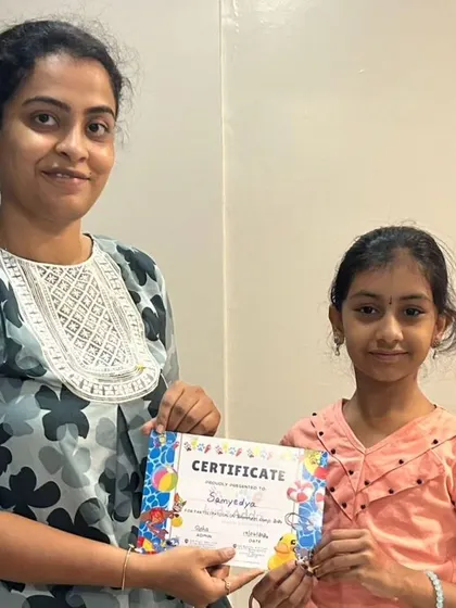 Another proud camper receives her certificate, marking the successful completion of the first batch of our summer camp.
