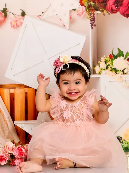 A beautiful, happy smile from this little girl in a pink dress. The floral and rustic props create a charming, shabby-chic vibe.
