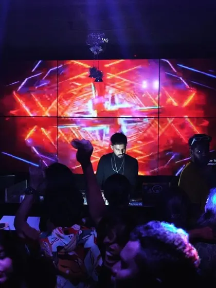Me at the decks, with the crowd vibing in front of a massive LED screen. A full audio-visual experience is what I aim for at every gig.