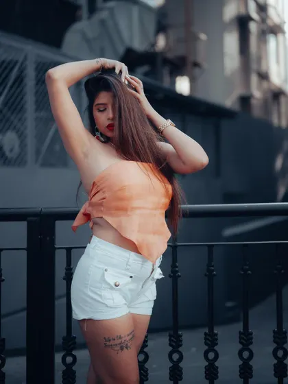 A full-body shot that captures a confident pose. The model's outfit and the urban setting make this a great example of modern street fashion.