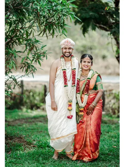 A classic, happy portrait of a newly married couple in their traditional wedding attire.