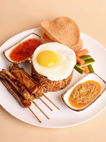 This Malay classic, Nasi Goreng, is a meal in itself. It comes with tender chicken skewers, fragrant seasoned rice, prawn crackers, and two of my secret sauces.