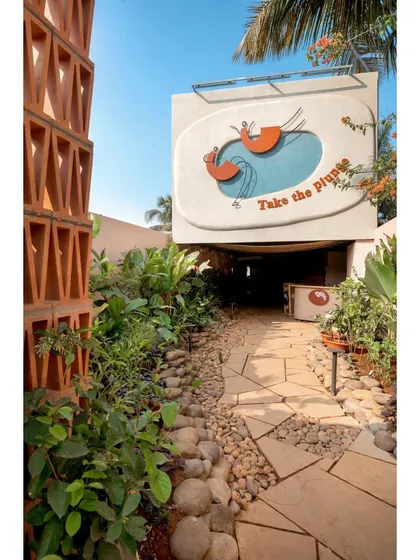 The entrance signage for Dubki, "Take the Plunge," is set against a backdrop of lush greenery and a terracotta brick jaali wall. This entry sequence immediately establishes the project's playful and nature-inspired theme.
