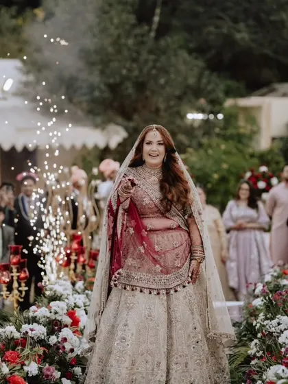 The bride's joyful entrance, surrounded by sparklers and loved ones. We capture the energy and excitement of this moment, making her walk down the aisle feel truly magical.