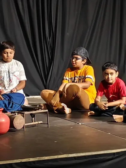 Another angle of a storytelling scene from a children's play, showcasing their focus and engagement.