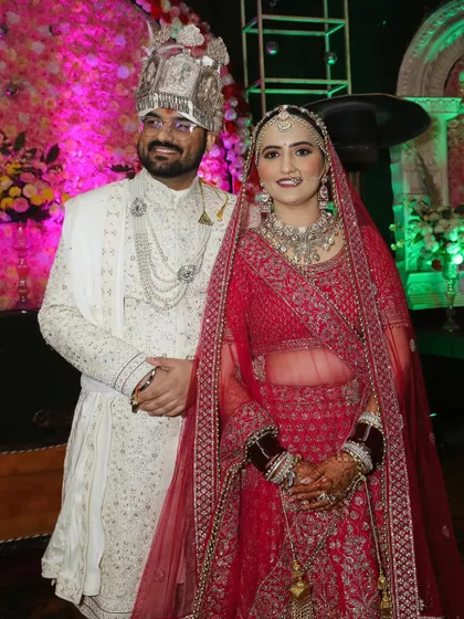 The happy couple posing for a picture on their wedding stage. They look so good together.