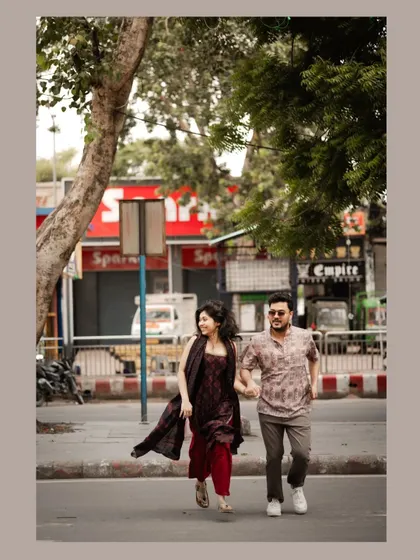 A fun, dynamic shot of a couple running and laughing across a city street, full of life and energy.