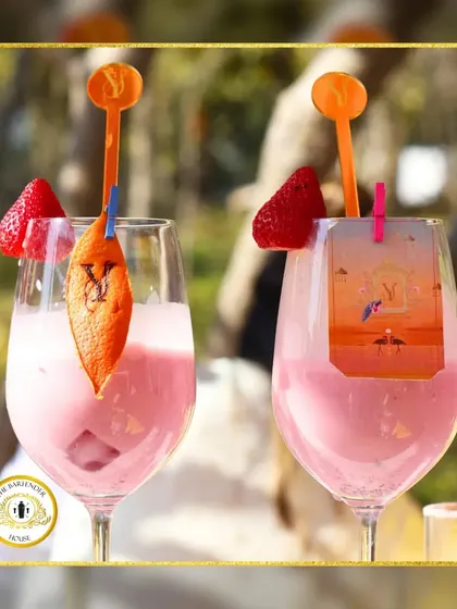 A custom-crafted pink cocktail for a wedding celebration. The drink is personalized with both an engraved orange peel and a custom tag, showing two ways we add detail.