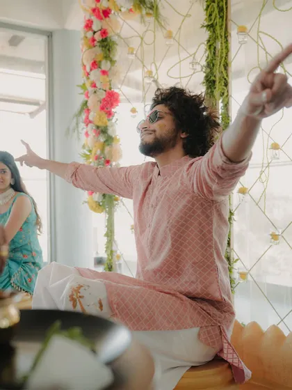 A classic "King of the world" pose by the groom during his Haldi, showing his excitement and happiness. We capture your personality in our shots.