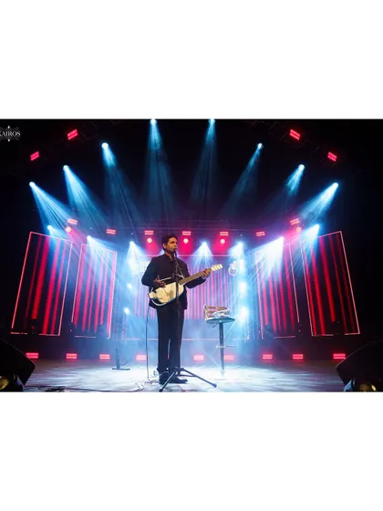 A performer on a beautifully lit stage. This wide shot emphasizes the stage design and the solitary presence of the artist.