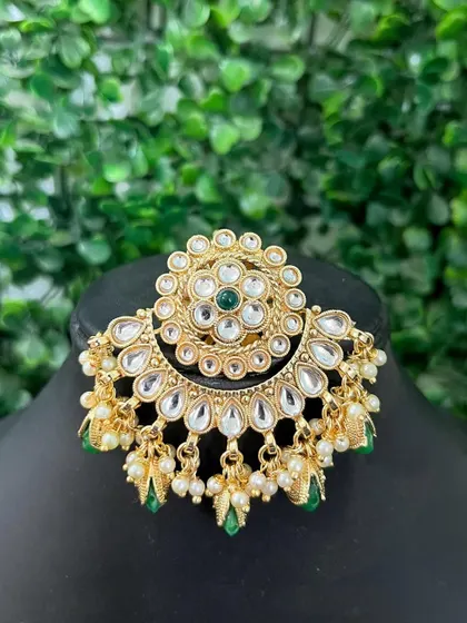 A passa-style earring with a floral kundan design and green bead drops. This rental piece is a unique and stylish choice.