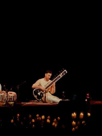 A full band performance in a candlelit setting, showing the scalability of the intimate experience from a solo act to an ensemble.
