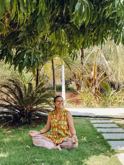 A student finds a peaceful spot to meditate on the grass. The ashram grounds are full of quiet nooks where you can be with yourself, surrounded by the calming presence of nature.