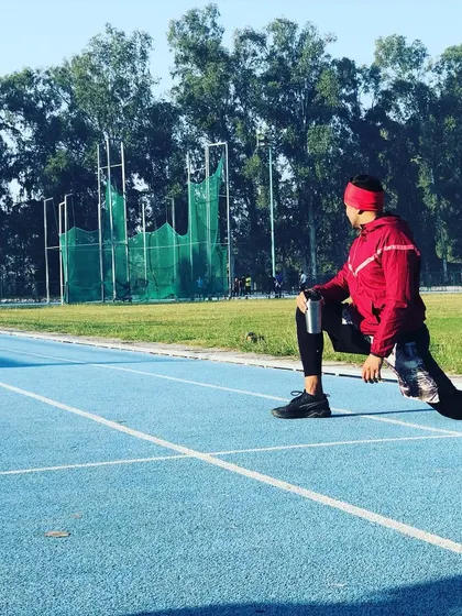 Taking the workout outdoors. Here, I'm stretching on a running track, reminding everyone that physical activity can and should happen anywhere.