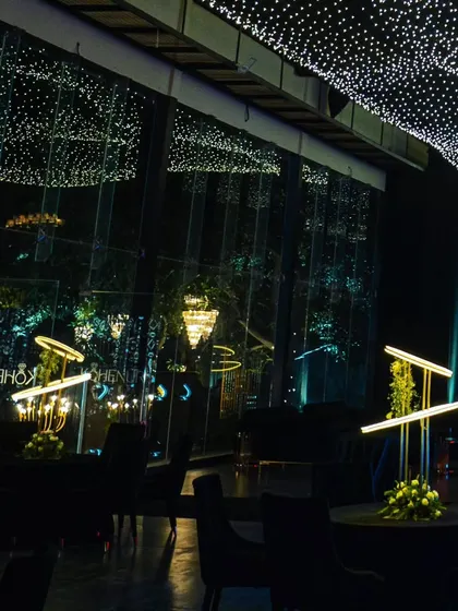The reflection of the starlit ceiling in the glass walls of the venue, creating an immersive and infinite feeling of being surrounded by stars.
