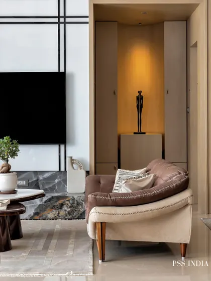 Simplicity and ethereal elegance define this living room corner. The two-tone sofa, nested coffee tables, and a carefully placed bonsai tree create a moment of calm and sophisticated style.